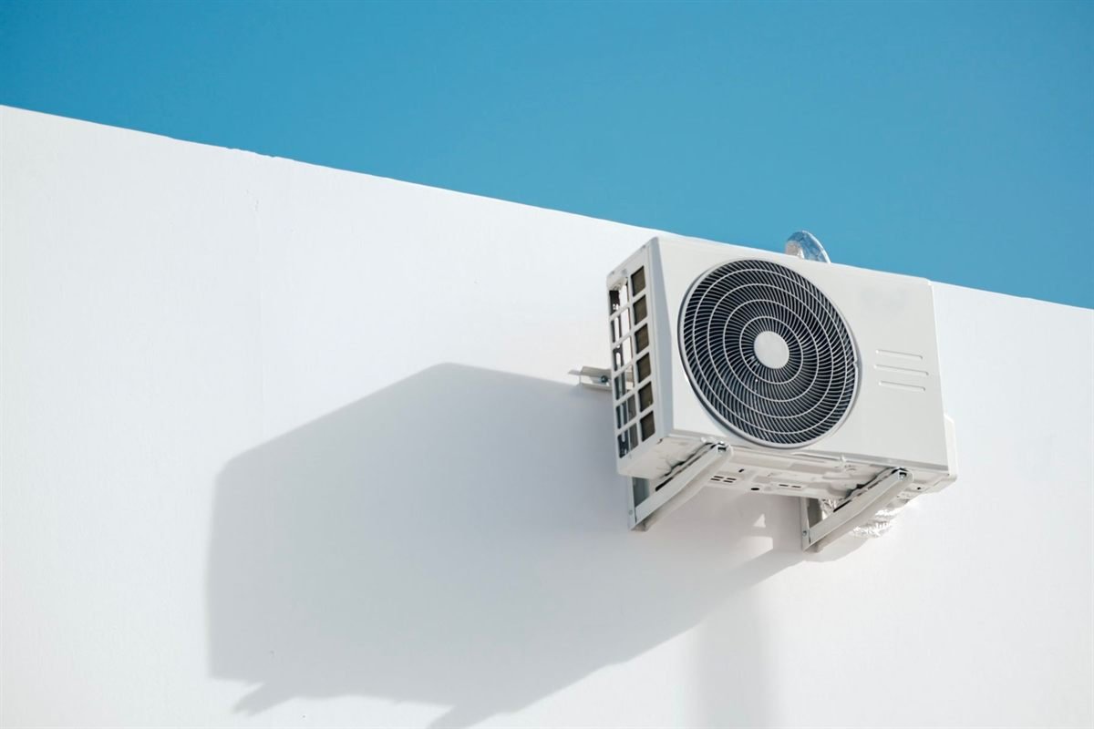 Unité extérieure de climatisation fixée sur un mur blanc